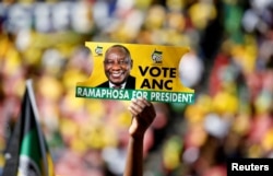 A supporter holds a placard with the face of President of South Africa's governing African National Congress Cyril Ramaphosa, during the party's final rally at Ellis Park Stadium in Johannesburg, South Africa, May 5, 2019.
