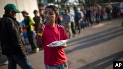 Dennis Mauricio Suarez, 12, from Honduras, eats breakfast at the Jesus Martinez stadium in Mexico City, Nov. 7, 2018. 