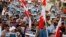 Anti-government protesters holding Bahraini flags and signs saying "No To Official Terror" march during a rally organized by Bahrain's main opposition party Al Wefaq on Budaiya highway west of Manama, August 23, 3013.