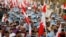 Anti-government protesters wave Bahraini flags, signs saying "No to Official Terror" during rally organized by country's main opposition party Al Wefaq, Manama, Aug. 23, 2013.