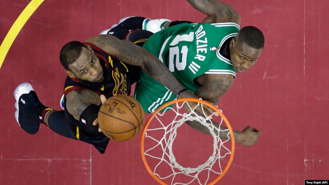 Košarkaš Klivlenda Lebron Džejms u prodoru ka košu pored Terija Rozijea (Boston), u drugom poluvremenu treće utakmice finala Istočne konferencije NBA plej-ofa (Foto: AP/Tony Dejak))