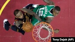 Košarkaš Klivlenda Lebron Džejms u prodoru ka košu pored Terija Rozijea (Boston), u drugom poluvremenu treće utakmice finala Istočne konferencije NBA plej-ofa (Foto: AP/Tony Dejak))