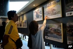 People look at photos of the Indian Ocean tsunami during the commemoration of the 20th anniversary of the disaster, in Banda Aceh, Indonesia, Dec. 26, 2024.