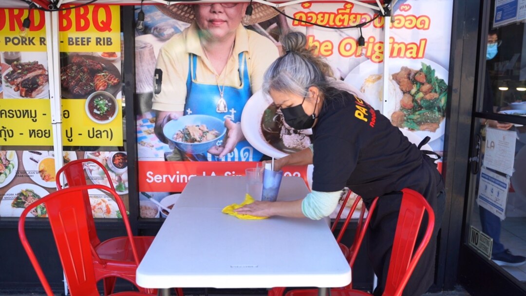A waitress cleans up a table at Pa Ord Noodle 3, a Thai restaurant in Los Angeles, CA. Sept 2021.