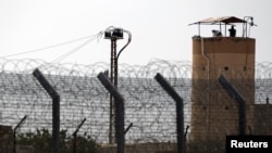 FILE - A member of Egypt's security forces stands on a watchtower in North Sinai as seen from across the border in southern Israel, July 1, 2015.