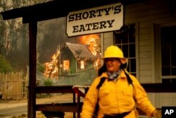 Pengawas Taman Nasional Negara Bagian California, Lori Martin mengawasi bangunan bersejarah saat Carr Fire membumi-hanguskan sebuah rumah di Shasta, California, 26 Juli 2018.