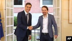 Spain's Prime Minister Pedro Sanchez, center, shakes hands with the leader of the Podemos party, Pablo Iglesias, at the Moncloa Palace in Madrid, Oct. 11, 2018.