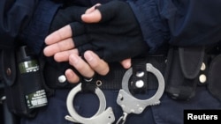 FILE - A Turkish riot police officer's handcuffs are pictured at the entrance of a courthouse in Istanbul. 