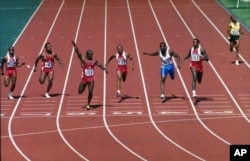 FILE - Canadian sprinter Ben Johnson, left, looks over at rival Carl Lewis at the finish of the 100-meter race in Seoul, South Korea, Sept. 24, 1988. Johnson was stripped of his gold medal for taking a banned steroid.