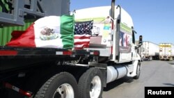 Camiones mexicanos con las banderas de México y Estados Unidos, en la frontera de Laredo.