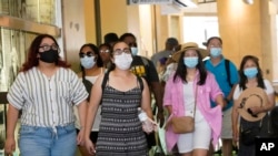 Sejumlah pengunjung mengenakan masker saat mengunjungi sebuah kompleks pertokoan di Los Angeles, 1 Juli 2021. (Foto: Marcio Jose Sanchez/AP)