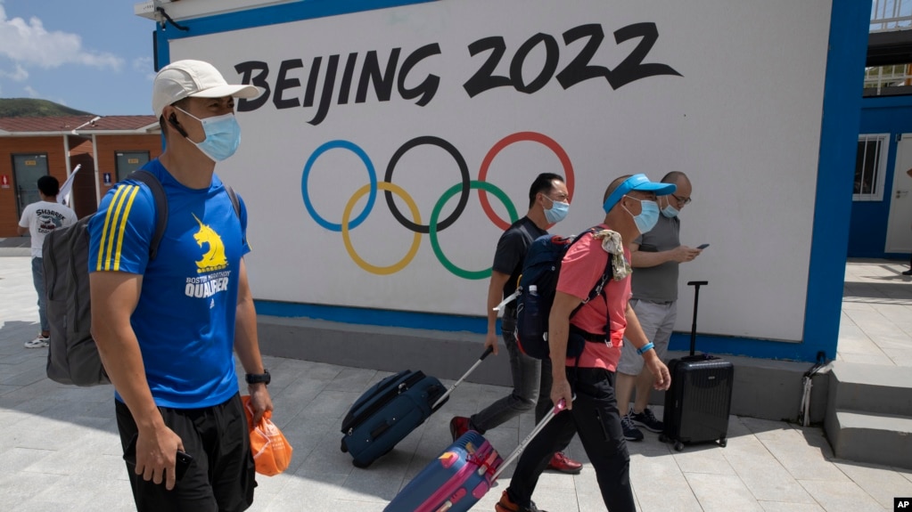 到河北省张家口崇礼的游客走过北京2022冬季奥运会的广告牌。（2020年8月13日）
