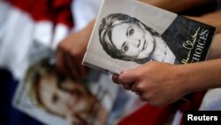 FILE - A supporter holds the book "Hard Choices" by Democratic U.S. presidential candidate Hillary Clinton before she speaks at a campaign event at the North Carolina State Fairgrounds in Raleigh, North Carolina, June 22, 2016.