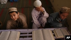 Pakistani religious students read Muslim's holy book the Quran, at a local madarassa or religious school in Karachi, Pakistan, March 6, 2010.