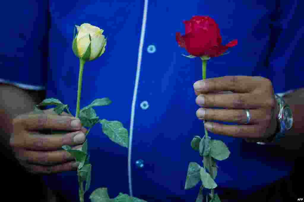 A member of a youth group holds roses as he prays for the missing Malaysia Airlines Boeing 777-200 plane at a hotel in Putrajaya, Malaysia.