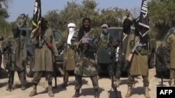 ພາບຈາກວີດີໂອ ສະແດງໃຫ້ເຫັນວ່າ ທ້າວ Abubakar Shekau (ກາງ) ຜູ້ນຳຂອງກຸ່ມ Boko Haram ພວມອ່ານຖະແຫຼງການ.