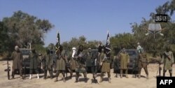 An image grab made on Oct. 31, 2014 from a video obtained by AFP shows the leader of the Islamist extremist group Boko Haram Abubakar Shekau (C) delivering a speech. (AFP photo/Boko Haram)