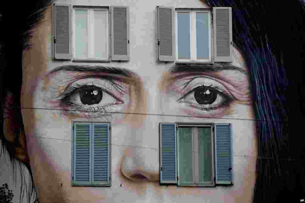 An art wall painting representing performance artist Marina Abramovic by Italian artist Maurizio Cattellan to publicize his upcoming exhibition The Artist is Present, in Shanghai, China, is displayed on a facade of a building, in Milan, Italy.