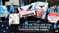 FILE - Uyghurs and their supporters gather across the street from United Nations headquarters in New York, Thursday, March 15, 2018. (AP Photo/Seth Wenig)