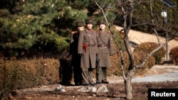 North Korean soldiers keep watch toward the south next to where a North Korean defected on Nov. 13, 2017, at Panmunjom inside the demilitarized zone, South Korea, Nov. 27, 2017.