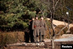 FILE - North Korean soldiers keep watch toward the south next to where a North Korean defected, Nov. 13, 2017, at Panmunjom inside the demilitarized zone, South Korea, Nov. 27, 2017.