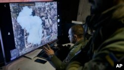 Ukrainian soldiers watch a drone feed from an underground command center in Bakhmut, Donetsk region, Ukraine, Sunday, Dec. 25, 2022.