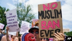 FILE — In this June 26, 2018, photo, protesters call out against the Supreme Court ruling upholding President Donald Trump's travel ban outside on Capitol Hill in Washington. The ban stops most visas for residents of mostly Muslim Libya, Iran, Somalia, Syria and Yemen.