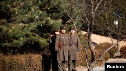 North Korean soldiers keep watch toward the south next to where a North Korean defected on Nov. 13, 2017, at Panmunjom inside the demilitarized zone, South Korea, Nov. 27, 2017.