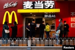 People wait for their orders outside a McDonald's restaurant, after the government banned dine-in services, following the coronavirus disease (COVID-19) outbreak in Beijing, China May 2, 2022. (REUTERS/Carlos Garcia Rawlins)