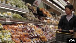 Seorang perempuan berbelanja di sebuah toserba Jepang di Hong Kong. Pejabat setempat juga telah meyakinkan konsumen untuk tidak khawatir dengan keamanan produk-produk pangan dan minuman dari Jepang.