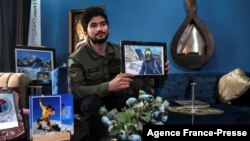 FILE - This picture taken Nov. 16, 2021, shows Pakistani mountaineer Shehroze Kashif holding a painting of himself during an interview with AFP at his home in Lahore.