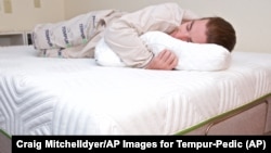 Sage Michaels, a student at Reed College in Portland, Oregon, lays on his new Tempur-Pedic® mattress that he won in a special competition by the company in 2017.