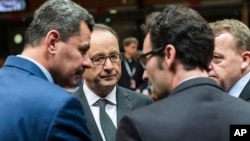 Le président français François Hollande converse avec le maire d'Alep, Brita Hagi Hasan, à gauche, et le Premier ministre danois Lars Lokke Rasmussen, deuxième de droite, lors d'une réunion de l'UE à Bruxelles, le 15 décembre 2016.