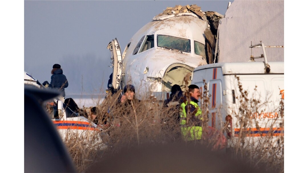 Police stand guard as rescuers assist on the site of a plane crash near Almaty International Airport, outside Almaty, Kazakhstan, Dec. 27, 2019. The Kazakhstan plane with 98 people aboard crashed shortly after takeoff early Friday.