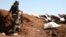 A Syrian rebel carries his machine gun during battles with pro-government fighters in western Daraa province, July 10, 2018. 