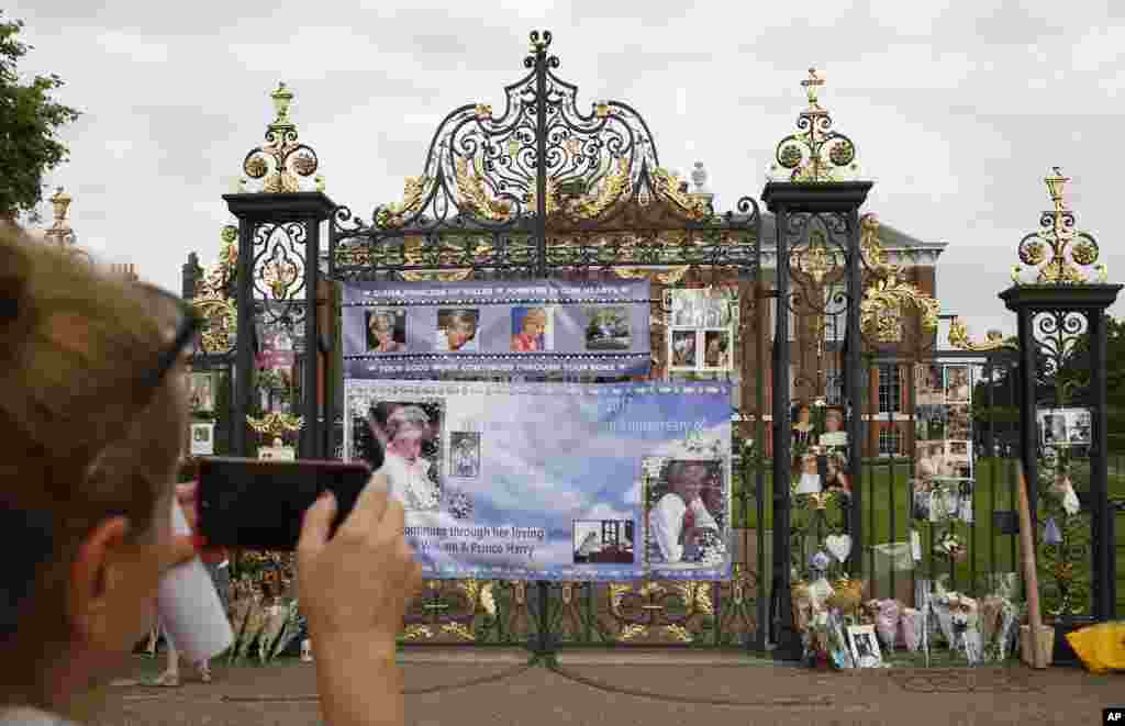 یک گردشگر از گلها و یادبود پرنسس دایانا عکس می گیرد. دایانا بعد از جدایی از ولیعهد انگلیس، بیست سال پیش در یک تصادف جان باخت.