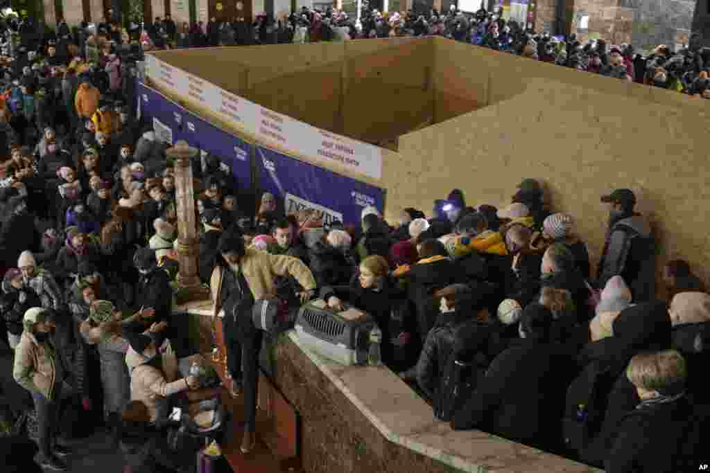 People struggle on stairways after a last minute change of the departure platform for a Lviv bound train in Kyiv, Ukraine, Feb. 28, 2022.