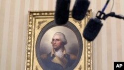 취재 장비들이 모인 백악관 대통령집무실(오벌 오피스)에 걸려있는 조지 워싱턴 초상.