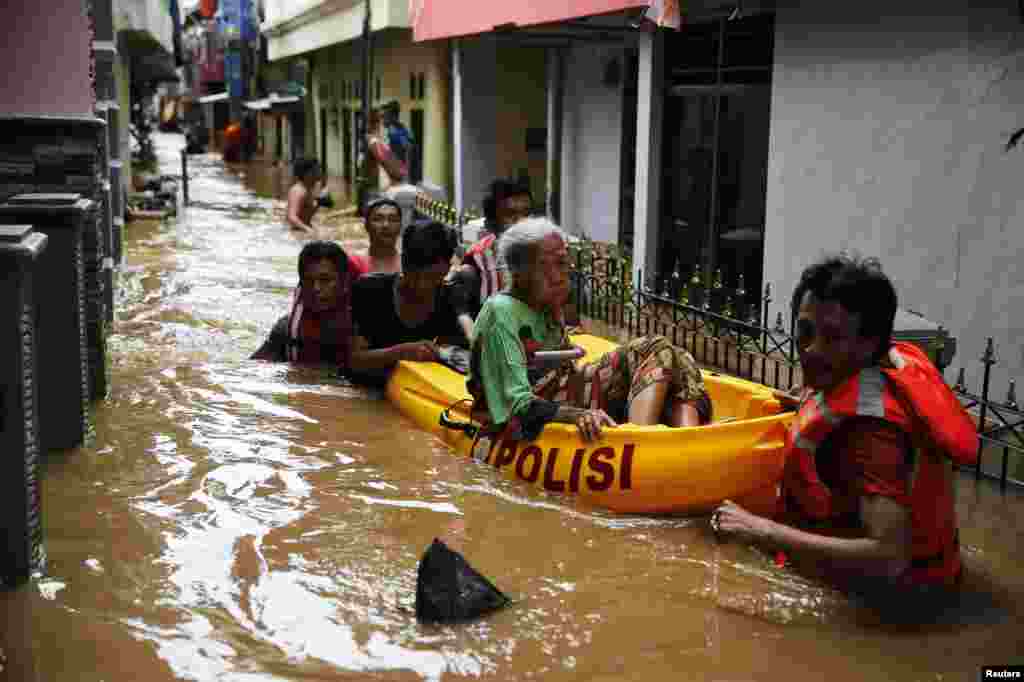 Các tình nguyện viên dùng bè đưa một cụ già đến nơi an toàn ở quận Jatinegara thuộc Jakarta, Indonesia. Mưa lớn đã gây ra ngập lụt ở một số nơi của thủ đô.