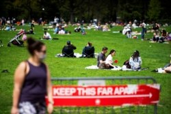 Orang-orang beristirahat dan menikmati hari di Central Park dengan menjaga jarak sosial saat pandemi Covid-19 di wilayah Manhattan, New York, 2 Mei 2020.