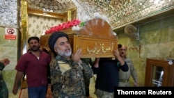 FILE - Mourners carry the coffin of a member of the Popular Mobilization Forces, who was killed in clashes with Islamic State militants in Salahuddin province, during the funeral in the holy city of Najaf, Iraq, May 3, 2020.