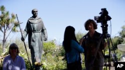 FILE - An interview is conducted next to a statue of Junipero Serra at the Carmel Mission in Carmel-By-The-Sea, Calif., Sept. 23, 2015. 