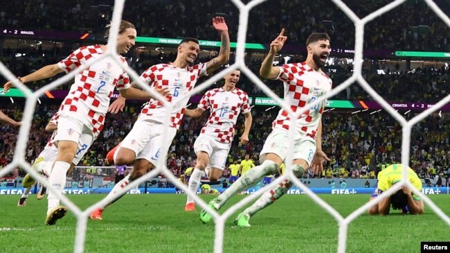 Josko Gvardiol dari Kroasia, Ante Budimir, Dejan Lovren, dan Lovro Majer merayakan kemenangan Kroasia ke semi final saat Marquinhos dari Brasil terlihat sedih setelah gagal mengeksekusi penalti dan tersingkir dari Piala Dunia. (Foto: REUTERS/Matthew Childs)