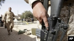 An Iraqi army soldier with an ink-stained index finger stands guard at the entrance to a polling station in central Baghdad, 04 Mar 2010