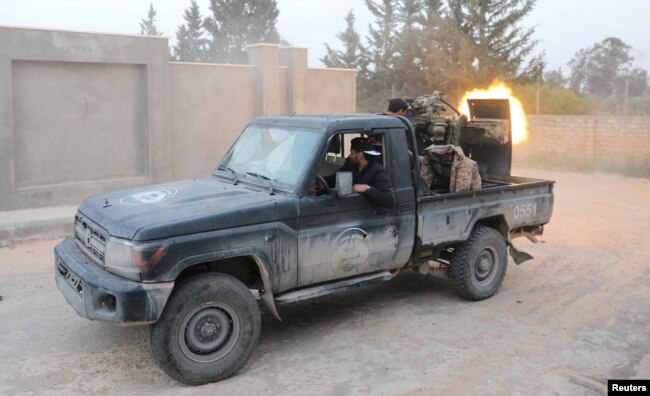 FILE - Members of the Libyan internationally recognized government forces fire during fighting with Eastern forces in Ain Zara in Tripoli, Libya, April 20, 2019.