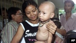 Dangati carries her 18-month-old son Ilan Susyandi, who is suffereing from malnutrition, to a hospital for treatment, Friday, June 17, 2005, in Jakarta, Indonesia. 