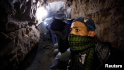 Palestinian worker moves goods through a smuggling tunnel between the Gaza Strip and the Egyptian Sinai February 19, 2013. 