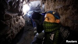 Palestinian worker moves goods through a smuggling tunnel between the Gaza Strip and the Egyptian Sinai February 19, 2013. 