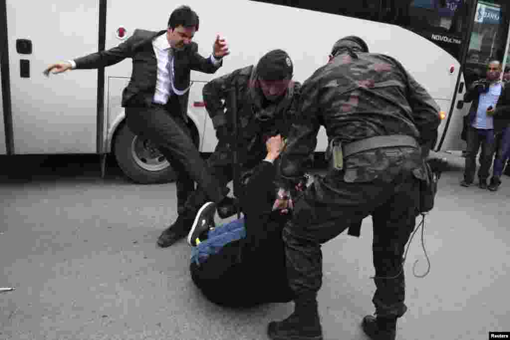 A protester is kicked by Yusuf Yerkel (left), advisor to Turkey&#39;s Prime Minister Tayyip Erdogan, as Special Forces police officers detain him during a protest against Erdogan&#39;s visit to Soma, where the mining disaster occurred, western province of Manisa, Turkey, May 14, 2014.