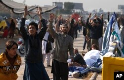 Supporters of the Tehreek-e-Labaik party chant religious slogans during a sit-in protest at an entrance to Islamabad, Pakistan, Nov. 26, 2017.